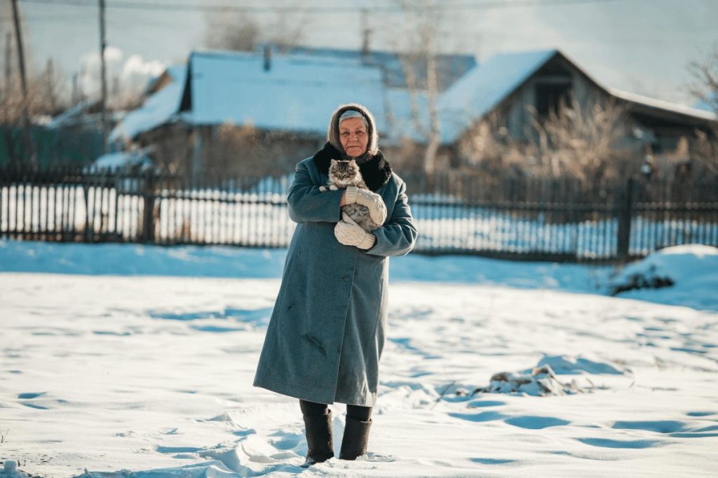 elderly woman holding cat outside